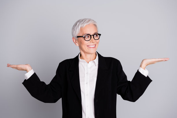 迷人可爱的高级女士穿着黑色西装的照片展示了灰色背景上孤立的空白空间图片下载