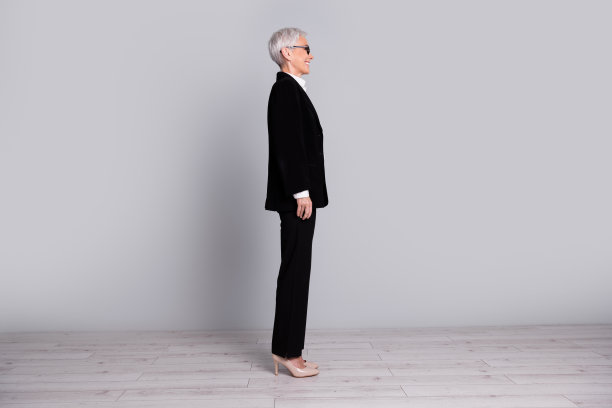 华丽成功的高级女士穿着黑色西装隔离在灰色背景的全长个人资料照片图片下载