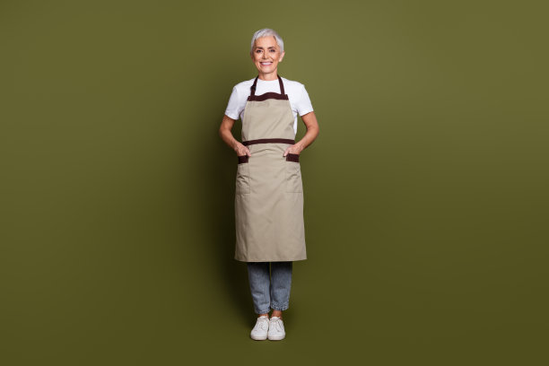 全身照片光泽自信的女士穿着围裙准备饮料微笑空空间孤立的绿色背景图片下载