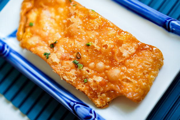 家庭餐桌上盘子里的即食脆皮烤肉的特写照片。图片下载