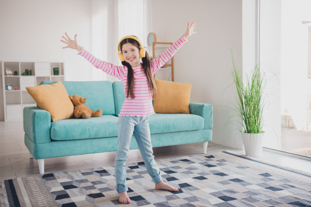 年轻有趣的孩子的照片肖像小黑发女孩呆在家里听音乐耳机独自跳舞举手孤立在她的房间图片下载