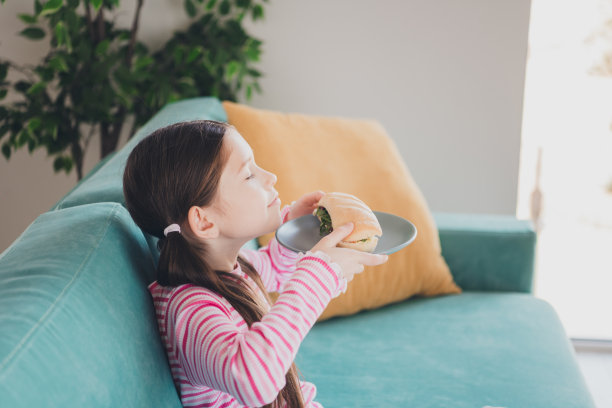 年轻有趣的孩子的照片肖像小黑发女孩呆在家里饥饿的气味很新鲜的法棍三明治孤立在她的房间里图片下载