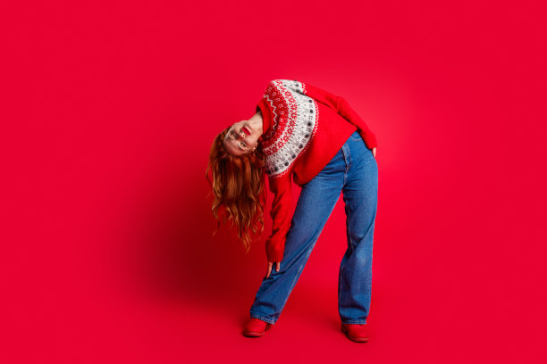 全身照片的年轻红发女士头朝下穿着季节性的冬季丑陋的毛衣孤立的红色背景图片下载