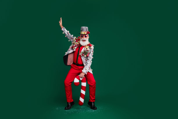 全尺寸照片的酷养老金老人圣诞老人男性舞蹈糖果玩具球小玩意在夹克帽子太阳镜孤立的绿色背景图片下载