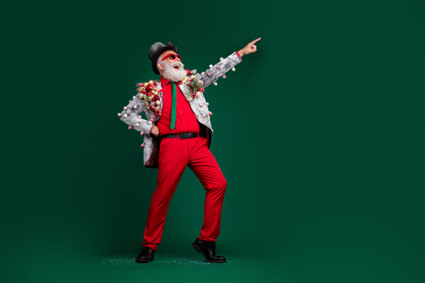 全尺寸照片的酷养老金老人圣诞老人男性点空的空间球，在夹克，帽子，太阳眼镜孤立的绿色背景图片下载