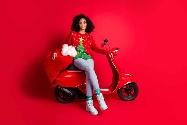 照片中可爱迷人的可爱女孩穿着毛衣准备新年礼物，魔法时间孤立在红色背景上图片下载