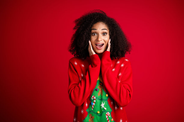 照片可爱可爱的有趣的女孩穿着时尚的装饰毛衣圣诞节日事件孤立的红色背景图片下载