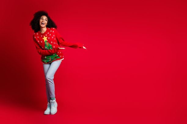 照片正面可爱迷人的女孩穿红色套头衫圣诞节魔术奇迹空白空间孤立在红色的背景图片下载