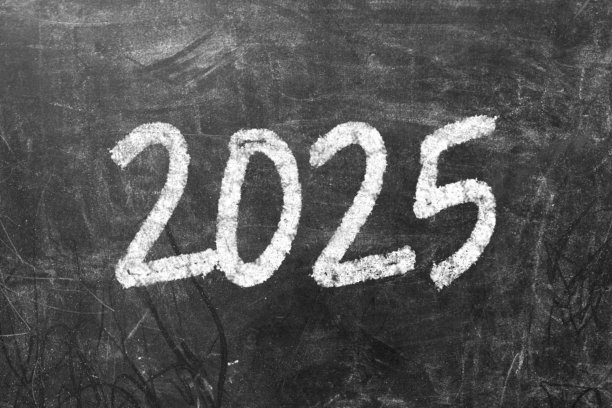 一只手在黑板上写着“2025”。新年快乐，新机遇，新理念。业务目标。图片下载