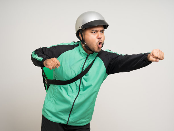 年轻的亚洲骑手穿着绿色夹克制服和头盔各种动作拿着很多纸包投递箱给客户。男服务员:快递、送货、送餐服务。图片下载