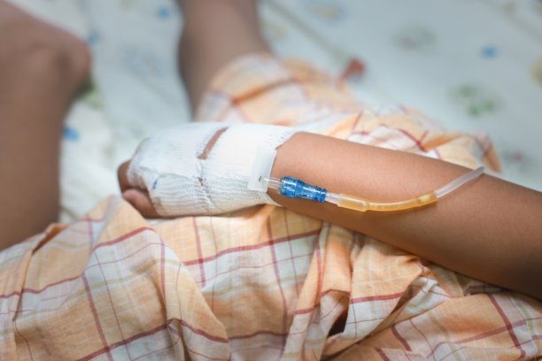 医院病房里病人的手，因为是甲型流感，用生理盐水管输液。关于治疗，急救，医疗，化疗，生病的概念。图片下载