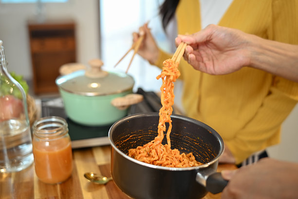 近距离观看年轻夫妇一起分享美味的饭菜，吃着黑锅里的酱面图片下载