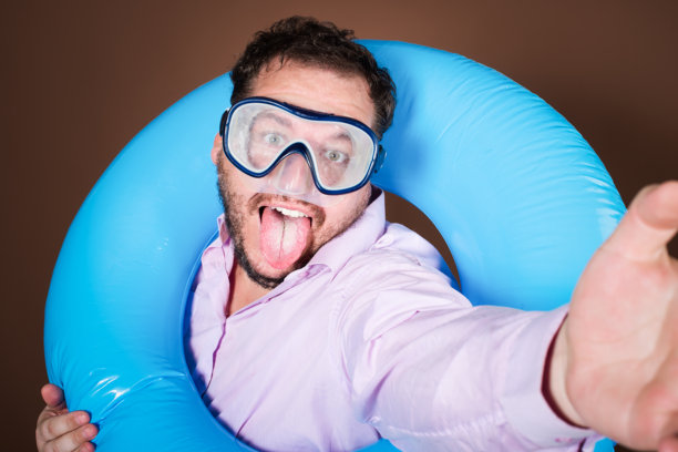 带着充气戒指的滑稽胖子要去度假了。图片下载