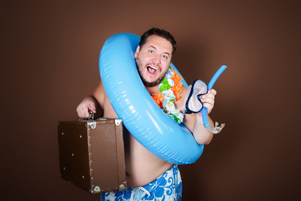 带着充气戒指的滑稽胖子要去度假了。图片下载