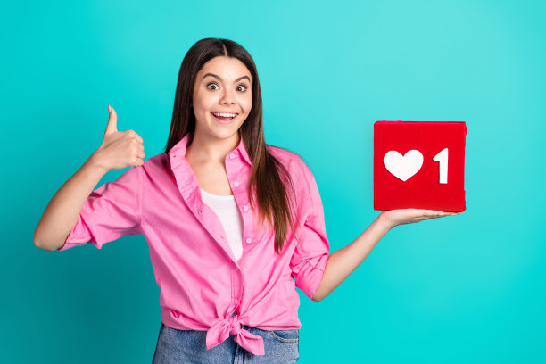 照片肖像可爱的少女女士持有像图标大拇指穿着时尚的粉红色服装孤立的青色背景图片下载