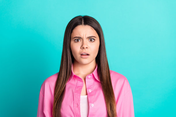 迷人的少女的照片肖像吓坏了，震惊的反应穿着时尚的粉红色衣服青色在蓝色的背景图片下载