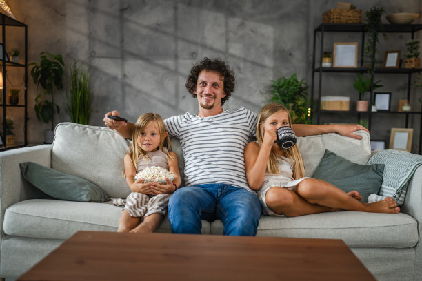 成年白人父亲在家里和女儿一起看电影，这是家庭时光图片下载