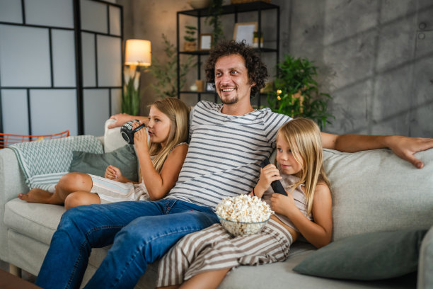 成年白人父亲在家里和女儿一起看电影，这是家庭时光图片下载