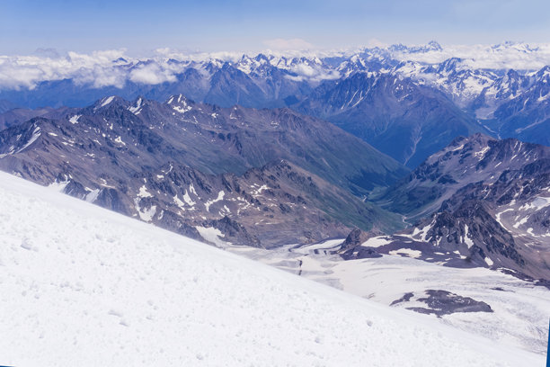 从厄尔布鲁士山的斜坡上俯瞰云层之上的高山图片下载