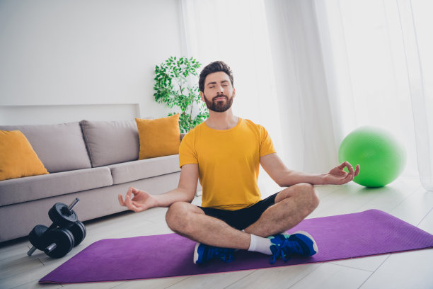 有吸引力的有趣的家伙的照片运动服微笑着享受早晨瑜伽在室内房间的房子图片下载