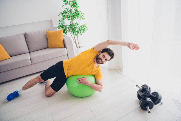 照片开朗积极的家伙运动服微笑享受健身球体育训练室内房子公寓房间图片下载