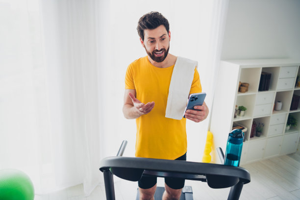 运动帅哥的照片教练博主健身房体育锻炼在跑步机上讲电话在家里室内图片下载