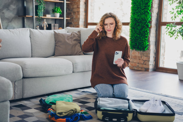 照片里可爱可爱的可爱女人穿着时髦的衣服把衣服提箱放在室内的房子里图片下载