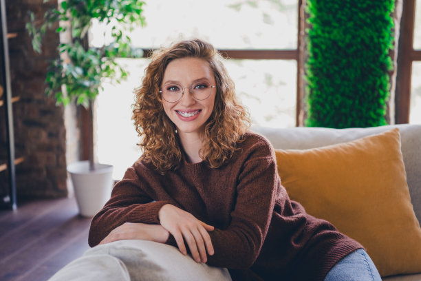 可爱可爱的女人坐在沙发上享受舒适的公寓房子家庭日光在室内的照片图片下载