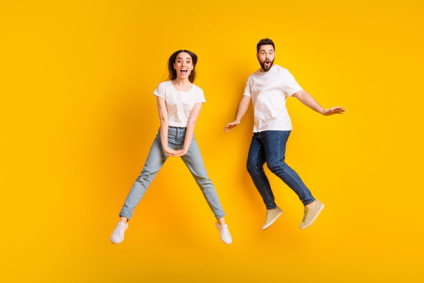 全身照片迷人的年轻男子女子跳俏皮有乐趣穿着时尚的白色衣服孤立在黄色的背景图片下载