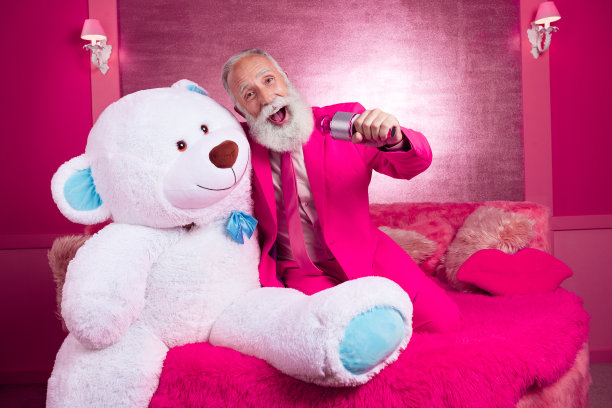 照片中疯狂成熟的爷爷男友唱歌抱着大泰迪熊在粉红色的房间里穿西装图片下载
