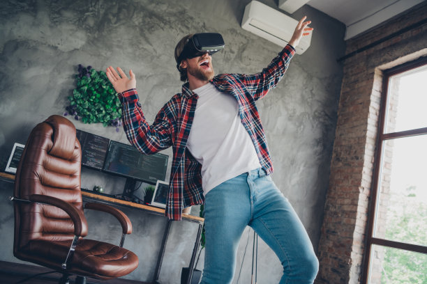 照片在阁楼娱乐现代设计客厅年轻的无忧无虑的家伙戴着虚拟现实耳机玩游戏的乐趣图片下载