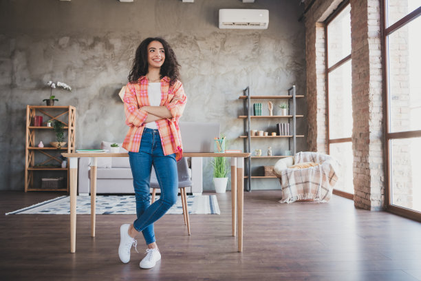 照片正面好心情的女人穿着橙色衬衫微笑双臂交叉在室内的房子公寓房间图片下载