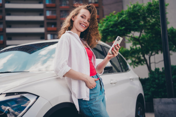 照片开朗可爱可爱的女孩靠在车上拿设备租赁应用程序穿白色衬衫享受自由时间阳光明媚的天气户外现代城市图片下载