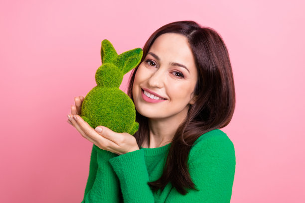 可爱的积极的人的手拿着毛茸茸的复活节兔子玩具孤立在粉红色的背景照片图片下载