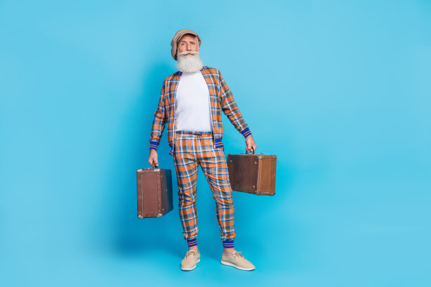 全长照片的酷严肃的爷爷拿着两个包穿格子孤立的蓝色背景图片下载