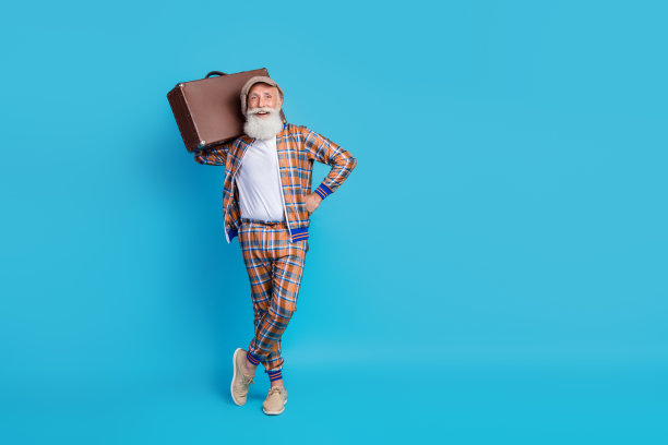 时髦男人的全身照片时髦的衣服拿行李等待登记飞往国外空空间孤立的蓝色背景图片下载