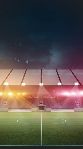 体育场灯光的3D渲染照亮了场地，突出了中心圆圈，背景是黑暗，暴风雨的天空，雨滴几乎看不见。图片下载