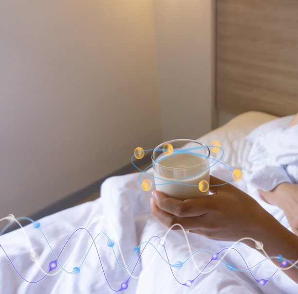 一位亚洲女性躺在床上，端着一杯豆浆，在床上喝牛奶，醒来时发现自己的卧室里有一张白色的床和毯子。图片下载