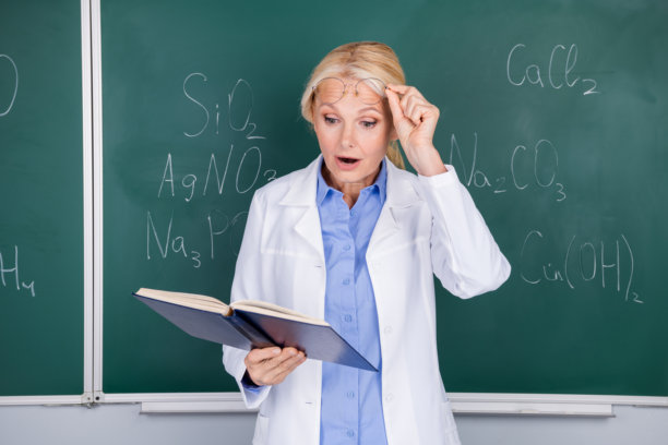 照片中，惊奇的聪明成熟的女大学老师穿着白色的大褂，戴着孤立在绿色背景板上的眼镜图片下载