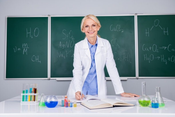 漂亮的女大学老师戴着白大褂眼镜的照片，在绿板背景上孤立地讲课图片下载