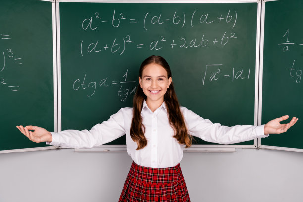 照片中可爱的十几岁的女学生勤奋地伸出双手欢迎穿着时髦校服的教室黑板背景图片下载