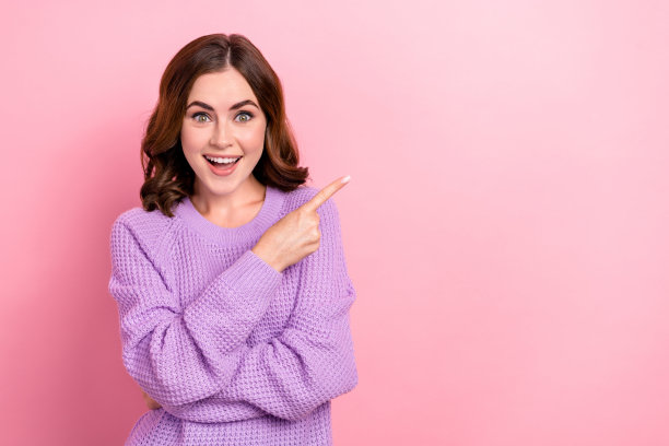 照片中，迷人可爱的女士穿着时尚的紫色春季服装，手臂上展示的是粉红色背景上的空档季促销图片下载