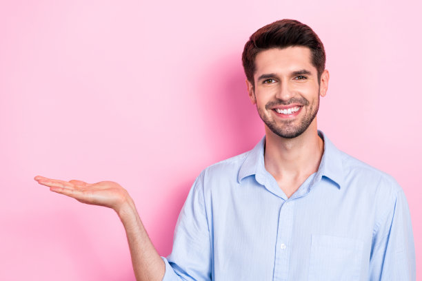 开朗的男子展示空白空间的照片推荐优质设备产品隔离在粉红色的背景图片下载