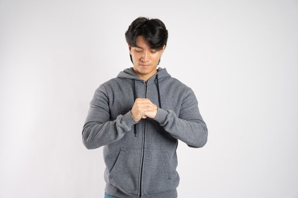 穿着连帽衫的亚洲男子在白色背景上摆姿势的肖像图片下载