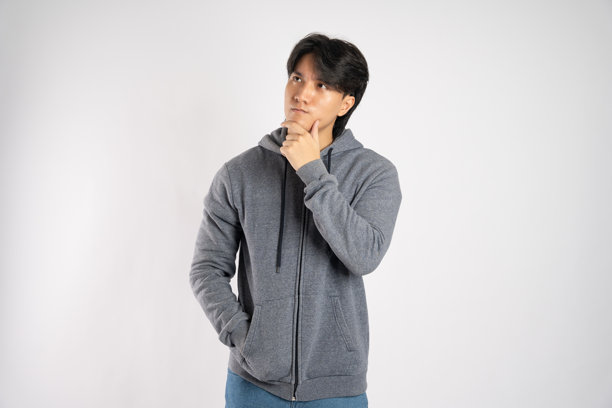 穿着连帽衫的亚洲男子在白色背景上摆姿势的肖像图片下载