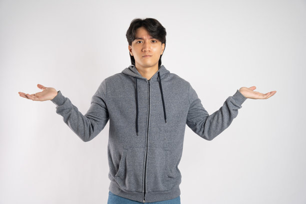 穿着连帽衫的亚洲男子在白色背景上摆姿势的肖像图片下载