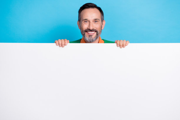 微笑的好心情的照片灰胡子商人拿着纸大招牌空白空间新药诊所品牌隔离在蓝色背景图片下载