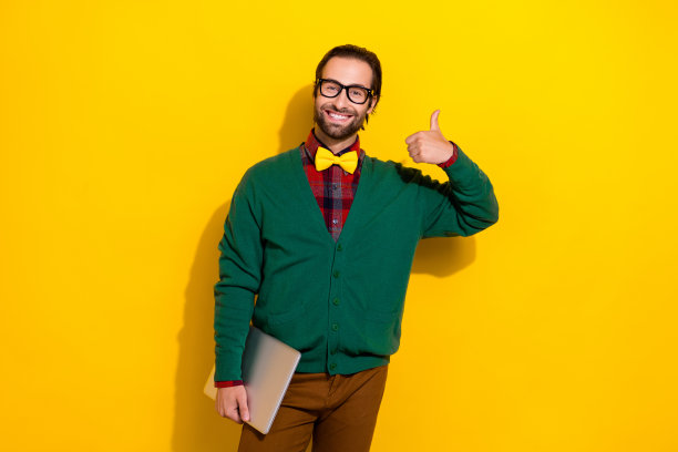 年轻的it开发者帅哥的照片，经验丰富的电脑用户赞同在明黄色背景上孤立的新策略图片下载