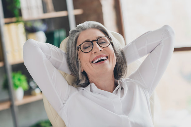 照片开朗积极的老人坐在皮椅上闭上眼睛牙齿微笑头后手臂完成工作办公室室内图片下载