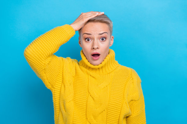 照片中，惊讶尴尬的女士穿着温暖舒适的衣服，蓝色背景上印着坏消息信息图片下载